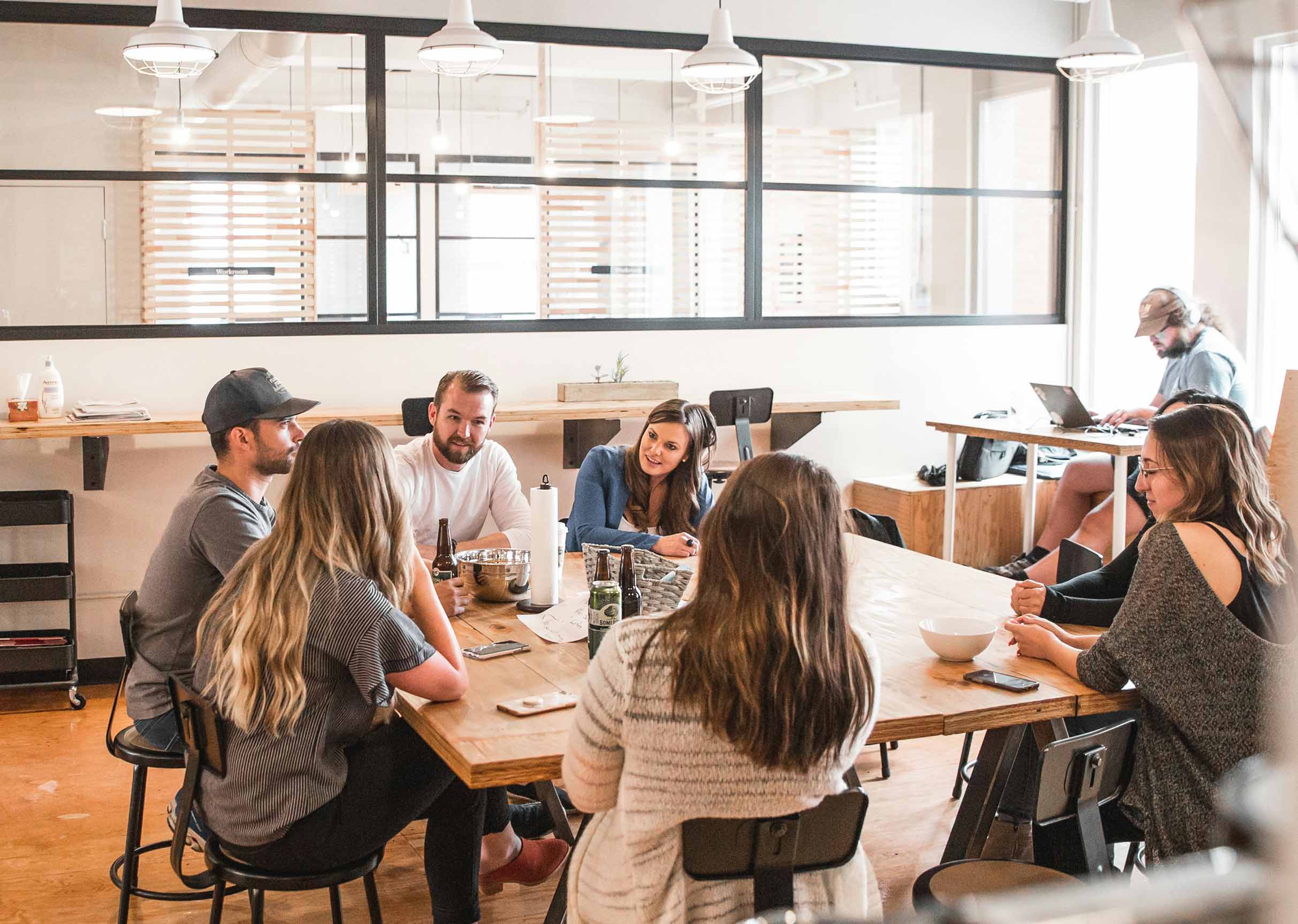 The WeBuildSaaS team collaborates around a table, symbolizing our open communication and dedicated support for non-technical founders seeking to build their SaaS vision.