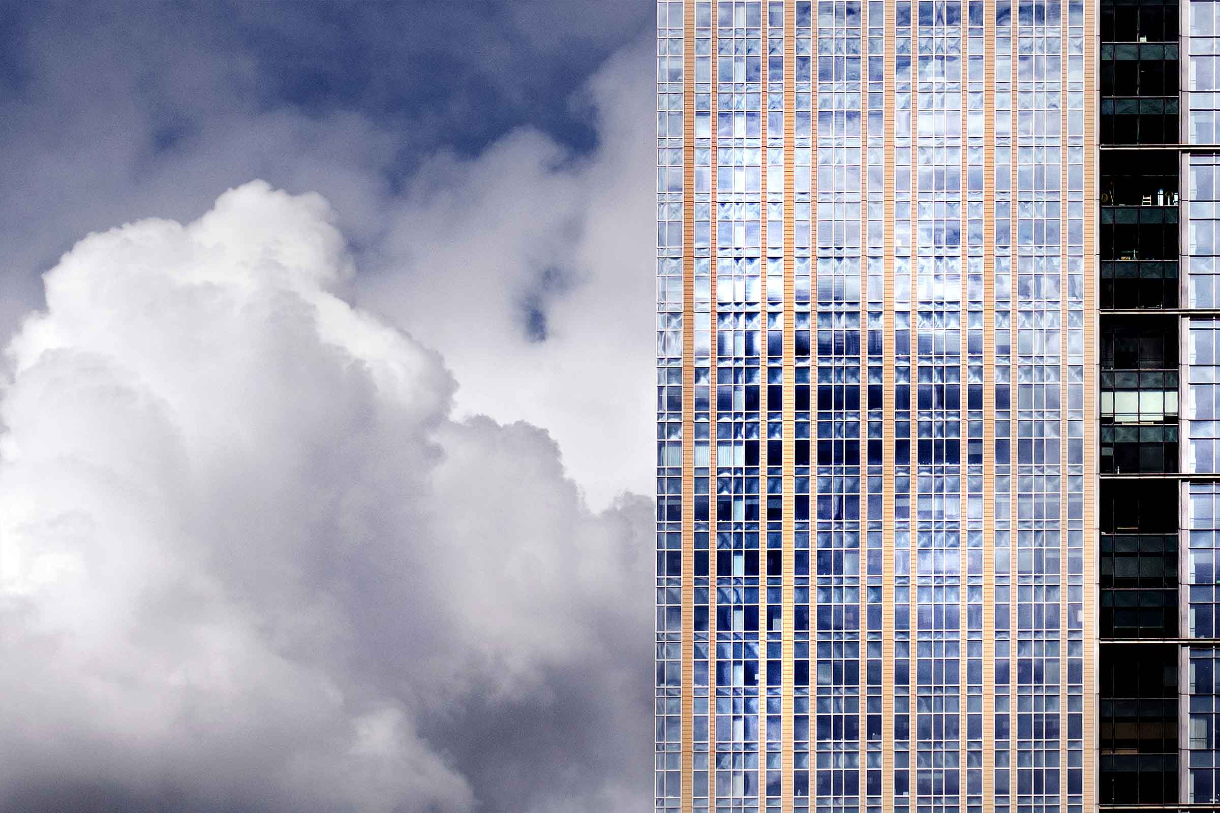 Modern skyscraper reaching through clouds into blue sky, symbolizing the rise and growth of vertical SaaS solutions targeting specific industries